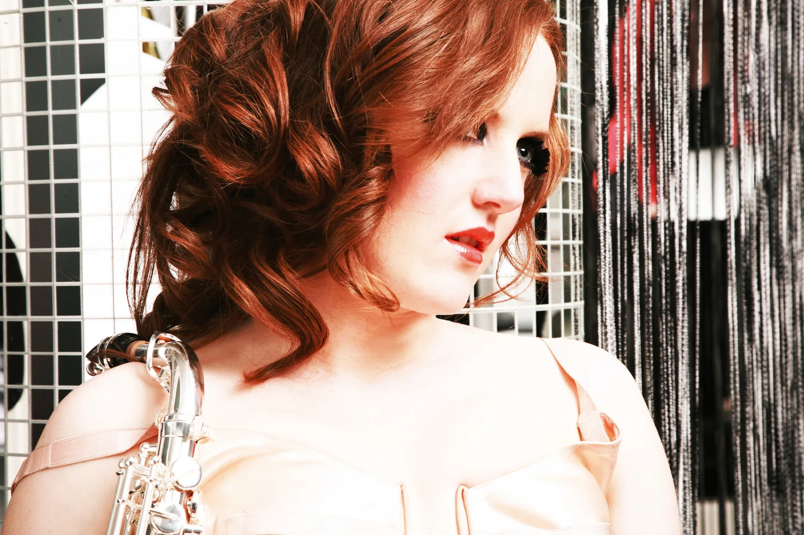 Female saxophonist portrait against a tinsel curtain