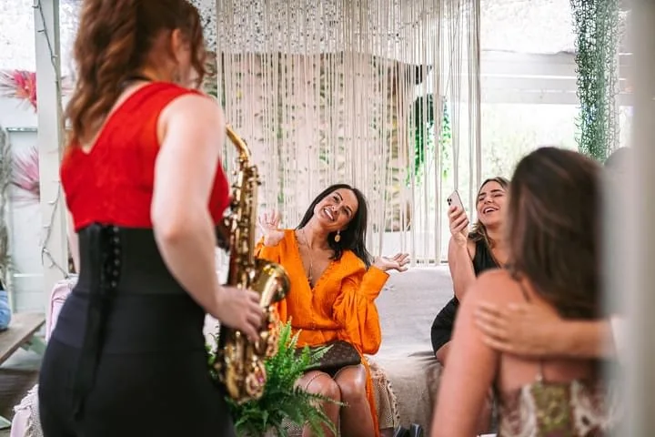 Sarah Saxophone entertaining guests alongside a DJ
