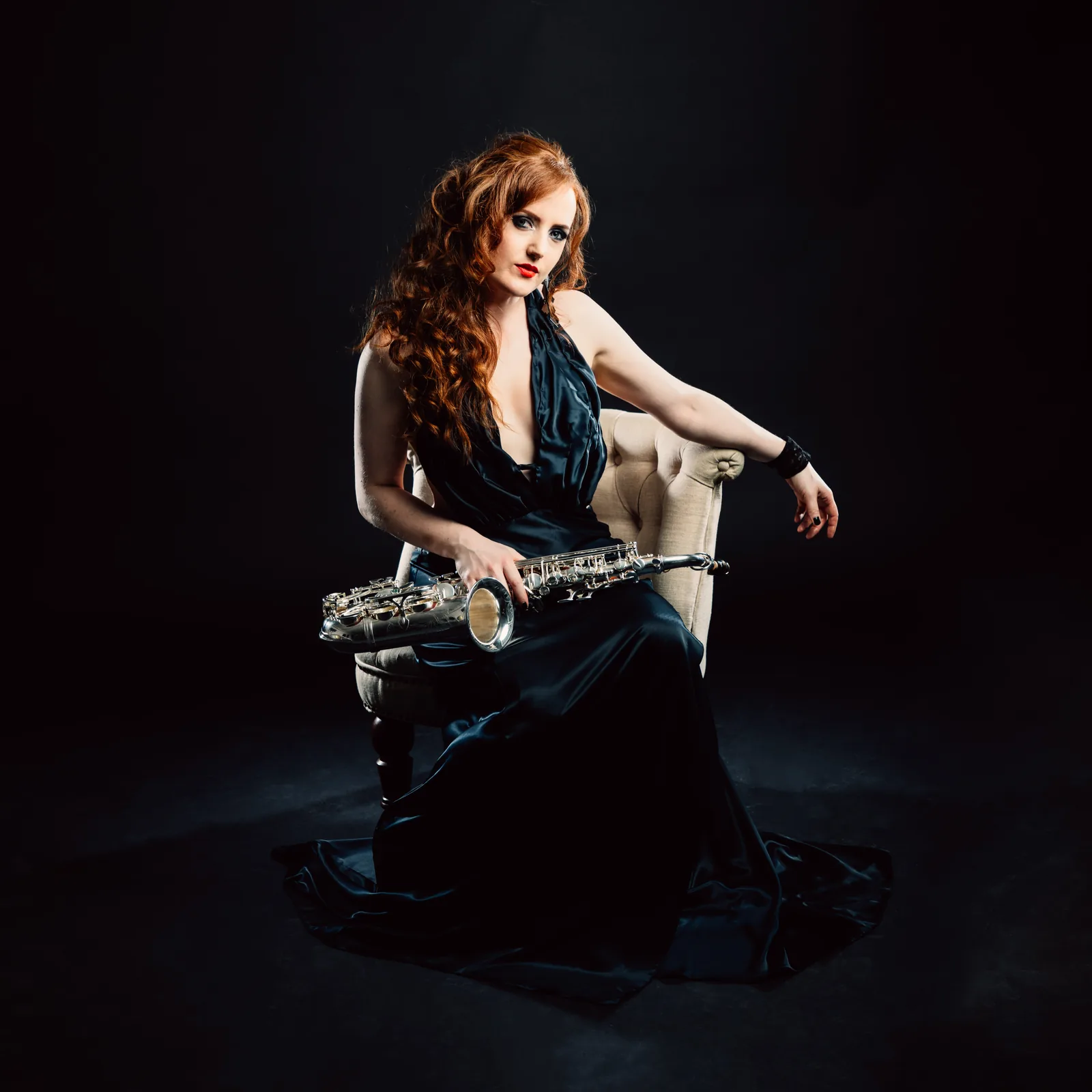 Sarah Saxophone in a white dress holding her saxophone