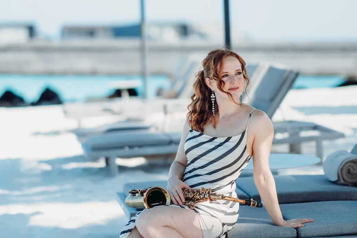 Sarah Saxophone relaxing poolside with her saxophone at a luxury yacht party