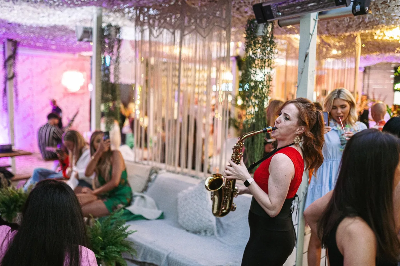 Sarah Saxophone performing at a purple-lit event